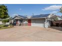 Cozy single-story home with solar panels, carport, red door, and well-maintained landscaping at 3027 S Clementine Dr, Tempe, AZ 85282