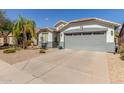 Single-story home showcasing a xeriscaped front yard, gray accents and attached two-car garage at 3284 W Five Mile Peak Dr, San Tan Valley, AZ 85144