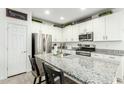 Modern kitchen featuring granite countertops, stainless steel appliances, and stylish white cabinetry at 4110 S 58Th Ln, Phoenix, AZ 85043