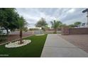 Well maintained front yard featuring a desert landscape, artificial turf, and a decorative stone border at 4546 N 84Th Ln, Phoenix, AZ 85037