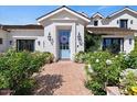 Elegant home facade with a light blue front door, brick path, and manicured bushes at 5446 E Exeter Blvd, Phoenix, AZ 85018