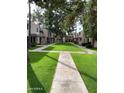 Community lawn with mature trees and sidewalks between units at 7126 N 19Th Ave # 103, Phoenix, AZ 85021