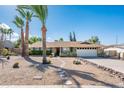 Single-story home with desert landscaping, a two-car garage, and an inviting front entrance at 725 E Country Gables Dr, Phoenix, AZ 85022