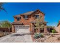 Two-story stucco home showcasing a tile roof, landscaped front yard, and a wide driveway leading to a two-car garage at 7252 N 90Th Ln, Glendale, AZ 85305