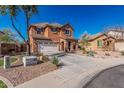 Two-story stucco home with a wide driveway, desert landscaping, tile roof, and a welcoming entrance at 7252 N 90Th Ln, Glendale, AZ 85305