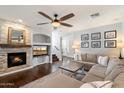 Cozy living room showcases a stacked stone fireplace, a large sectional, and stylish decor, perfect for relaxation at 7428 W Montgomery Rd, Peoria, AZ 85383