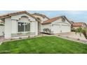 Charming single-Gathering home featuring lush green lawn and desert landscaping at 7543 E Keats Ave, Mesa, AZ 85209