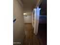 Hallway featuring wood floors, an archway, and a built-in bookshelf for ample storage at 8727 N 35Th Dr, Phoenix, AZ 85051