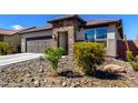 Attractive single-level home featuring a stone entryway, desert landscaping, and a convenient attached two-car garage at 8836 S 165Th Ave, Goodyear, AZ 85338