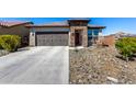 Inviting single-story home with a two-car garage, stone accents, a tidy desert landscape, and a concrete driveway at 8836 S 165Th Ave, Goodyear, AZ 85338