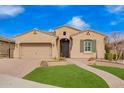 Charming single-story home featuring a two-car garage, desert landscaping, and a walkway leading to the front door at 9302 W White Feather Ln, Peoria, AZ 85383