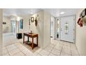 Bright entryway featuring neutral tile flooring, coat rack and a view into the living area at 9813 W Sandstone Dr, Sun City, AZ 85351