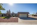 Charming single-story home featuring desert landscaping and an attached two-car garage at 9813 W Sandstone Dr, Sun City, AZ 85351