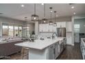 Open-concept kitchen with a large island, stainless steel appliances, and seamless transition to living area at 12702 W Sierra Vista Dr, Glendale, AZ 85307