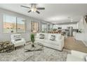 Bright living room with modern furniture and an open layout, seamlessly connected to the kitchen and dining areas at 17176 W Molly Ln, Surprise, AZ 85387