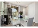 Bright dining room with a modern glass table, white chairs, wine cooler, and patio access at 1756 E Bridgeport Pkwy, Gilbert, AZ 85295
