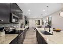 Kitchen features dark cabinets, granite countertops, tile backsplash, and stainless steel appliances at 1756 E Bridgeport Pkwy, Gilbert, AZ 85295