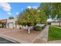 Inviting single-story home showcasing a mature orange tree, a two-car garage, and a neatly landscaped front yard at 1951 N 64Th St # 69, Mesa, AZ 85205