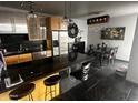 Modern kitchen and dining area with dark counter tops, stainless steel appliances, and stylish black accents at 207 W Clarendon Ave # G18, Phoenix, AZ 85013