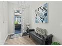 Stylish entryway with a black leather bench, modern art, and hardwood floors at 20718 W Colter St, Buckeye, AZ 85396