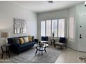 Bright living room with a blue sofa, decorative pillows, and plantation shutters at 2164 W Megan St, Chandler, AZ 85224