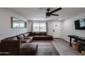 Bright living room features a comfortable leather sectional, neutral paint, and a ceiling fan at 3520 E Ludlow Dr, Phoenix, AZ 85032