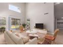 Bright living room featuring vaulted ceilings, light wood floors, and sliding glass doors to backyard at 4714 E Angela Dr, Phoenix, AZ 85032
