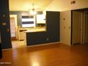 Spacious living area with hardwood floors connecting to kitchen with breakfast bar seating and white cabinetry at 5704 E Aire Libre Ave # 1036, Scottsdale, AZ 85254