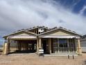 New home in progress featuring wood framing and architectural details under a partly cloudy sky at 7694 W Saddlehorn Rd, Peoria, AZ 85383