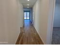 Well-lit hallway with wood-look tile flooring leading to the living spaces and featuring neutral paint at 7694 W Saddlehorn Rd, Peoria, AZ 85383
