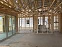 Spacious interior view with exposed wooden beams, glass sliding doors, and visible ductwork, offering a glimpse of the home's structure at 7694 W Saddlehorn Rd, Peoria, AZ 85383