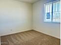 Bright bedroom with neutral carpet, white walls, and a window providing ample natural light at 7701 W Avenida Del Rey --, Peoria, AZ 85383