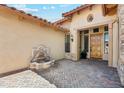 View of the front door entrance with pavers and a water fountain on a sunny day at 7915 E Stonecliff Cir, Mesa, AZ 85207