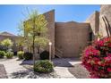 Exterior view of a well-maintained building with desert landscaping including flowering bougainvillea at 8155 E Roosevelt St # 231, Scottsdale, AZ 85257