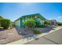 A charming single-story home surrounded by desert landscaping with palm trees, greenery and gravel accents at 8500 E Southern Ave # 447, Mesa, AZ 85209