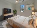 Relaxing bedroom features a large window, ceiling fan and a modern accent cabinet at 9327 E Static Ave, Mesa, AZ 85212