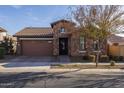 Stunning stone facade home with a manicured lawn, brown garage door, and charming curb appeal at 10141 E Tamery Ave, Mesa, AZ 85212