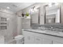 Bright bathroom featuring a marble-topped vanity, dual sinks, and a modern shower with decorative tile accents at 10602 N 35Th St, Phoenix, AZ 85028