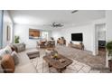 Open-concept living room with stylish furnishings, seamlessly flowing into the dining area and kitchen at 11729 W Maui Ln, El Mirage, AZ 85335