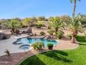 Gorgeous backyard featuring a sparkling pool, relaxing spa, lush palm trees, and a built-in barbeque at 13126 E Turquoise Ave, Scottsdale, AZ 85259