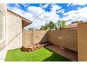 View of the fenced backyard with low-maintenance artificial turf at 1316 N 85Th Pl, Scottsdale, AZ 85257