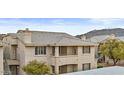 Multi-story condo showcases its tile roof and balconies, set against a backdrop of desert terrain at 16013 S Desert Foothills Pkwy # 2120, Phoenix, AZ 85048