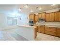 Bright kitchen featuring wooden cabinets, a breakfast bar, and modern stainless steel appliances at 18624 E Cattle Dr, Queen Creek, AZ 85142