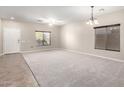 Spacious living room featuring neutral walls, carpeted floors, bright windows, and a ceiling fan at 19061 N Toya St, Maricopa, AZ 85138