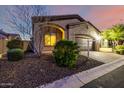 Exterior view of home featuring desert landscaping, including decorative stone and healthy bushes surrounding the driveway at 2124 N 89Th Pl, Mesa, AZ 85207