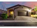 Charming home exterior with a two-car garage, stone accents, manicured landscaping, and a well-paved driveway at 2124 N 89Th Pl, Mesa, AZ 85207