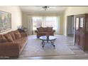 Inviting living room with plush seating, a ceiling fan, and natural light streaming through the large window at 2710 S Noche De Paz --, Mesa, AZ 85202