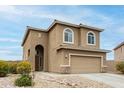Inviting two-story home featuring an arched entryway and neutral desert tones at 284 N 199Th Dr, Buckeye, AZ 85326