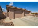 Garage exterior showing 3 car garage with stone accents and neutral desert landscaping at 2842 S Royal Wood --, Mesa, AZ 85212