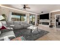 Open living room featuring a modern fireplace, neutral tones, plush seating, and bright, natural light at 2842 S Royal Wood --, Mesa, AZ 85212